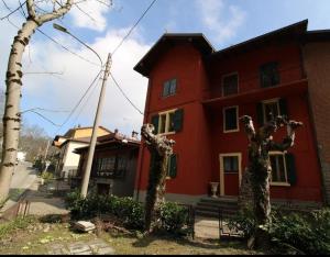 a red building with two trees in front of it at Locanda San Nicolo - Sestola Centro in Sestola