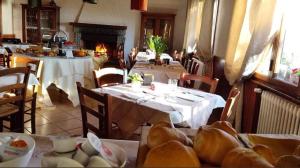 a dining room with two tables and a fireplace at Locanda San Nicolo - Sestola Centro in Sestola
