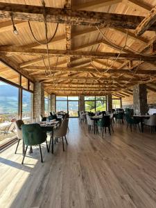 a dining room with tables and chairs and windows at Cottages Jasavić in Plav