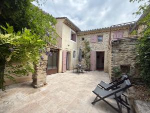 an outdoor patio with a table and an umbrella at Chez Marie in Grignan