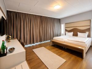 a hotel room with a bed and a table at Hotel Dortmund City in Dortmund
