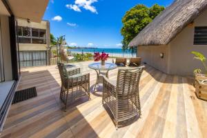 a patio with a table and chairs and the ocean at Beachfront villa by M&H in Tamarin