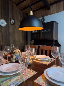 a table with glasses and plates and a lamp at Casa Enxaimel Aurora in Pomerode +9 photos