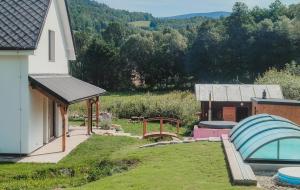 a backyard with a house and a building with a pool at Prázdninový dům Sobotín in Sobotín