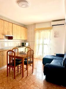 a kitchen with a table and chairs and a couch at Apartamento 1 minuto del mar in El Pozo del Esparto