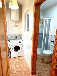 a bathroom with a washing machine and a toilet at Apartamento 1 minuto del mar in El Pozo del Esparto