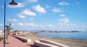 a beach with two benches and a street light at Apartamento 1 minuto del mar in El Pozo del Esparto +1 photo