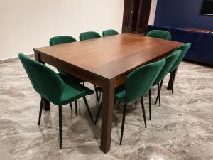 a wooden table with green chairs in a room at Charis Tanjong Jara Villa Emerald in Dungun +35 photos