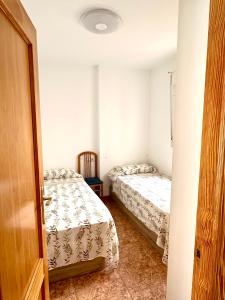 a room with two beds and a door open at Apartamento 1 minuto del mar in El Pozo del Esparto