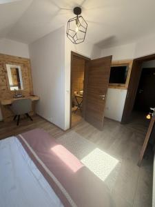 a room with a bed and a door and a table at La Colțul Castelului Bran Boutique in Bran