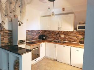 a kitchen with white cabinets and a sink at Holiday Home Alegra in Podgora