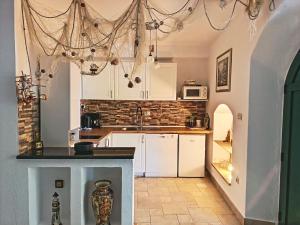a kitchen with white cabinets and a black counter top at Holiday Home Alegra in Podgora