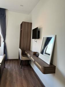 a hotel room with a desk and a mirror at Doge Hotel in Quảng Ngãi