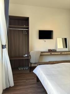 a hotel room with a bed and a television at Doge Hotel in Quảng Ngãi +22 photos