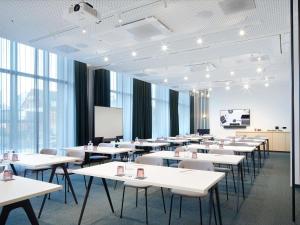 a classroom with tables and chairs in a room with windows at Novotel Hamburg Central Station in Hamburg