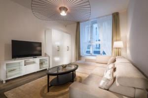 a living room with a couch and a tv at Modern Designed Oldtown Square Apartment in Prague