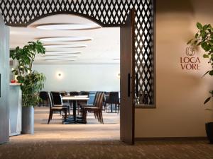 an open door to a dining room with a table and chairs at Mercure Urabandai Resort & Spa in Kitashiobara
