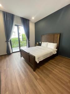 a bedroom with a large bed and a large window at Doge Hotel in Quảng Ngãi