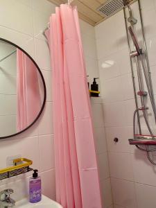 a pink shower curtain in a bathroom with a sink at Katas Suite, Helsinki city center in Helsinki