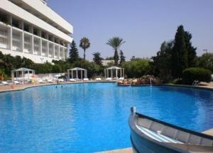 a large swimming pool with a boat in front of a building at A urassi an HTT hotel in Isly