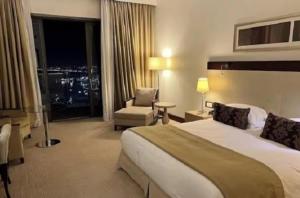 a large hotel room with a bed and a chair at A urassi an HTT hotel in Isly