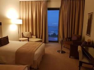 a hotel room with a bed and a large window at A urassi an HTT hotel in Isly