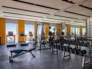 a gym with a lot of treadmills and machines at Novotel Riyadh Sahafa in Riyadh