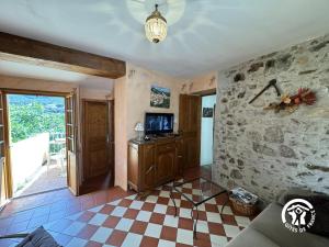 a living room with a tv and a checkerboard floor at Ca la rigalla in Amélie-les-Bains-Palalda