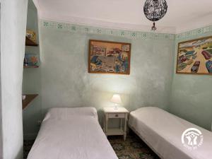 a bedroom with two beds and a table with a lamp at Ca la rigalla in Amélie-les-Bains-Palalda