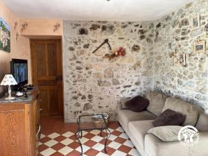 a living room with a couch and a stone wall at Ca la rigalla in Amélie-les-Bains-Palalda +8 photos
