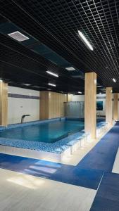 a large swimming pool in a large building at Chotqol Sanatorium in G‘azalkent