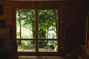 an open window with a view of a garden outside at Bukowica Miła - Dom z sauną w sercu Natury 2000 in Wola Piotrowa