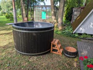 a large hot tub in a yard with a wooden ladder at Kaberneeme Puhkemaja - Kaberneeme Holiday Home in Kaberneeme