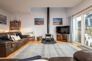 a living room with a couch and a flat screen tv at Craiglea - Elie & Earlsferry in Earlsferry