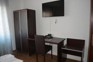 a desk with a phone and a chair in a room at B&D Hotel in Hannover