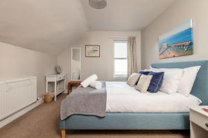 a bedroom with a blue and white bed and a window at Craiglea - Elie & Earlsferry in Earlsferry