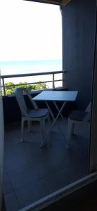 a balcony with a table and two chairs on a balcony at À la brise marine in Saint-Benoît