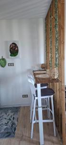 a kitchen with a counter and a table and stools at À la brise marine in Saint-Benoît