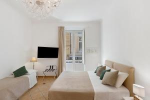 a white room with a bed and a chandelier at Sorrentina Guest House in Sorrento