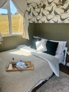 a bedroom with a bed with a tray on it at Cabin on the Moors in Llansannan