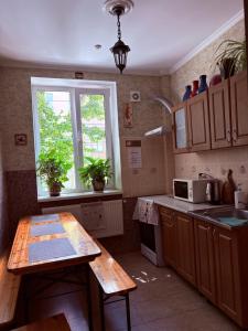 a kitchen with a wooden table and a window at Hotel Kardinal in Vinnytsya