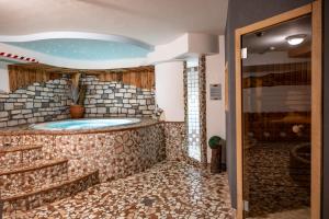 a bathroom with a tub in a stone wall at Hotel Orchidea in Passo del Tonale +51 photos