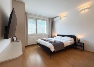 a bedroom with a bed and a large window at Cozy Emerald Studio Bratislava in Bratislava +15 photos