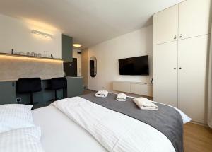 a bedroom with a large bed with two towels at Cozy Emerald Studio Bratislava in Bratislava