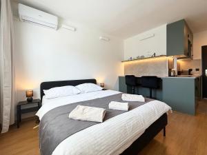 a bedroom with a large bed with two towels on it at Cozy Emerald Studio Bratislava in Bratislava
