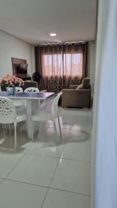 a living room with a table and chairs and a couch at Apartamento Maragogi Peroba in Maragogi +6 photos