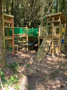 a wooden playground with a slide in the woods at Gîte de la forêt in Mont-de-Vougney