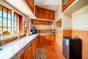 a kitchen with wooden cabinets and a black refrigerator at Paradise Farm 20 min from Rabat By MasterHost with AC in Salé