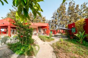 a red house with tables and chairs in front of it at Paradise Farm 20 min from Rabat By MasterHost with AC in Salé
