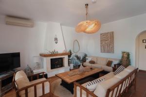 a living room with a couch and a fireplace at Villa Kyma in Aegina